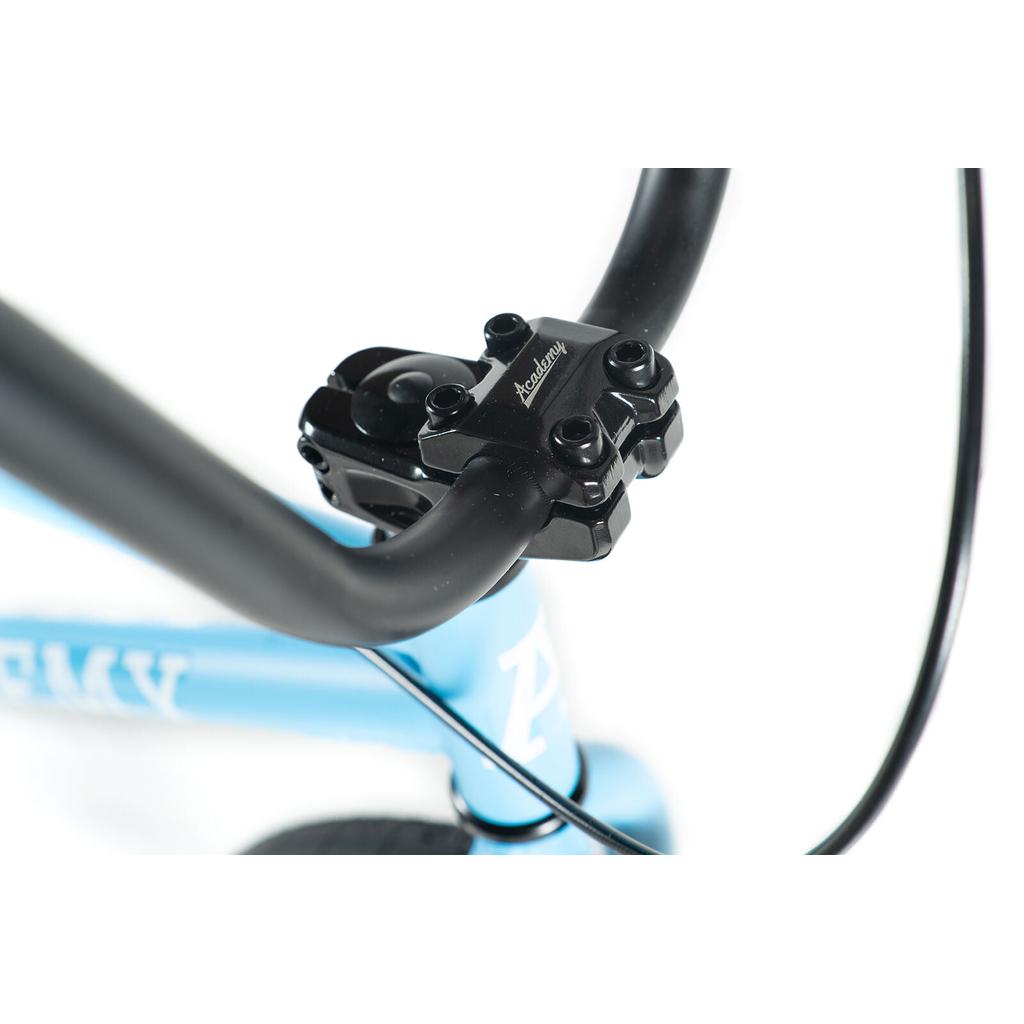 Close-up view of a black BMX stem and handlebar attached to the light blue Academy Trooper 20 Inch Bike frame, with a visible cable running along the handlebars.