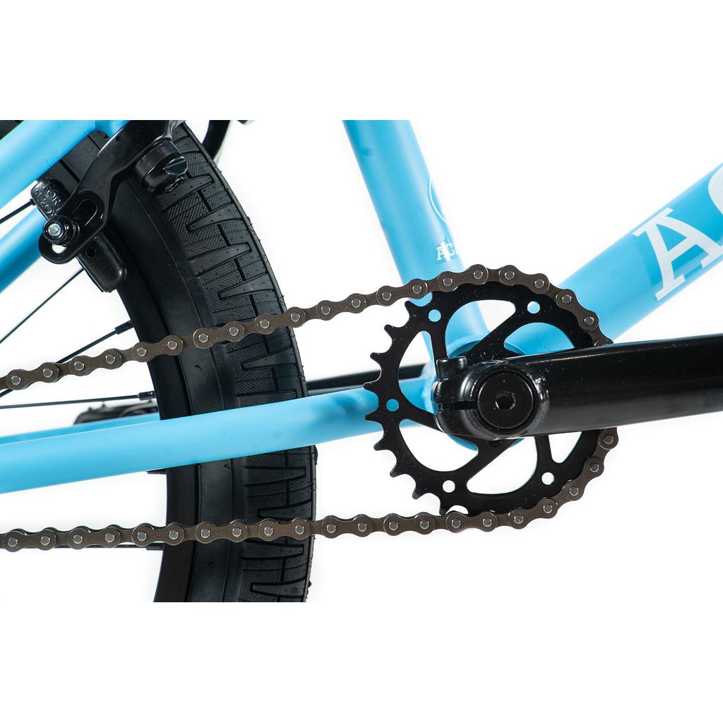 Close-up of the black chain and chainring on the Academy Trooper 20 Inch Bike’s light blue frame, with the rear tire, sealed hubs, and part of the brake visible in the background.