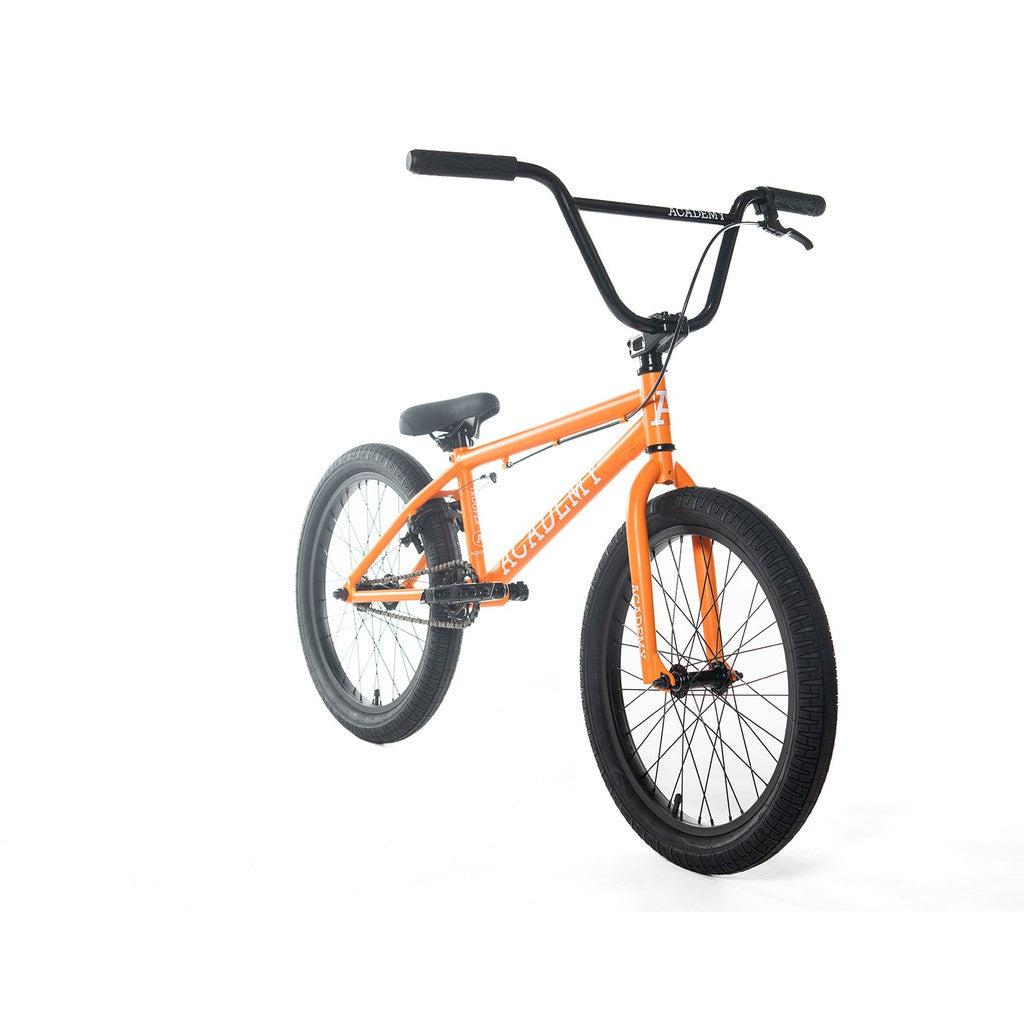The Academy Trooper 20 Inch Bike is displayed from a front-left angle against a pristine white background, highlighting its bold orange Hi-Ten steel frame paired with black handlebars and tires. Its performance is further improved by the inclusion of durable sealed hubs.