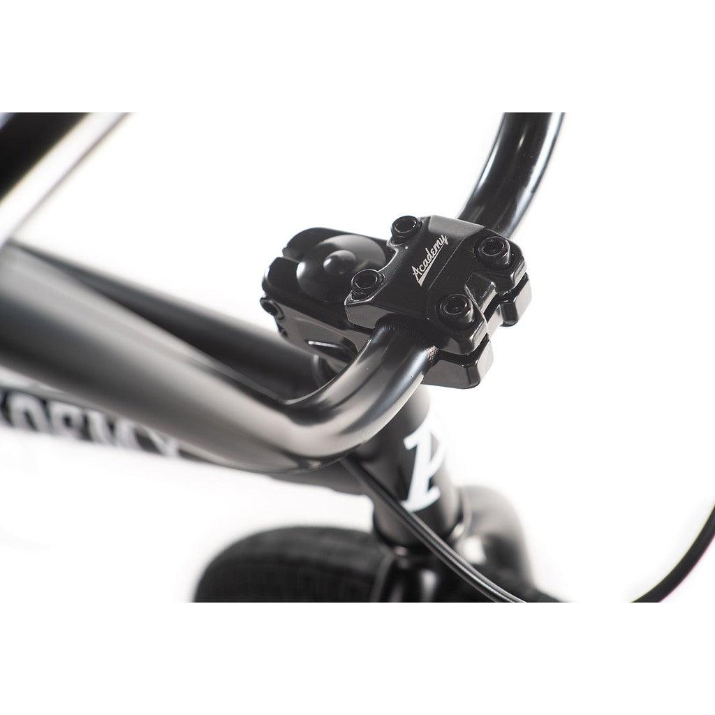 Close-up of black bicycle handlebars with a four-bolt stem, featuring the Academy Trooper 20 Inch Bike logo.