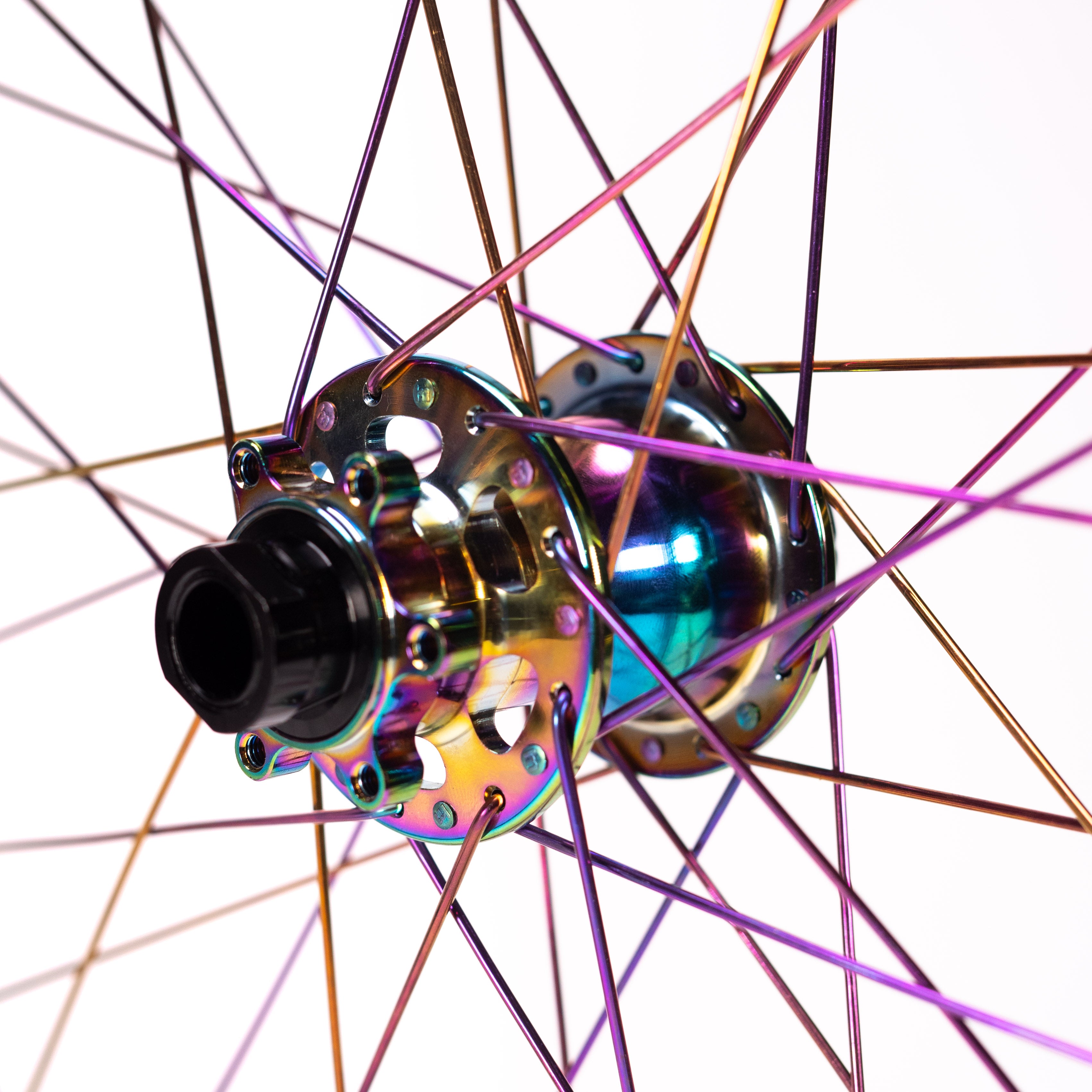 Close-up of a bicycle wheel hub with an iridescent finish, showcasing colorful spokes, from the Arise Echo Oilslick Pro 20 Inch Wheelset with tubeless-ready rims.