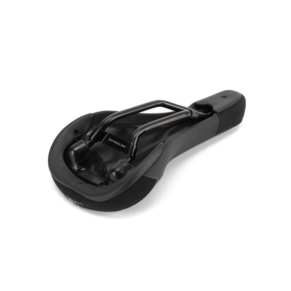 The image shows the underside of the Arise Sensor Railed Seat, a black bicycle saddle with metal rails for mounting and textured padding, ideal for downhill riding.