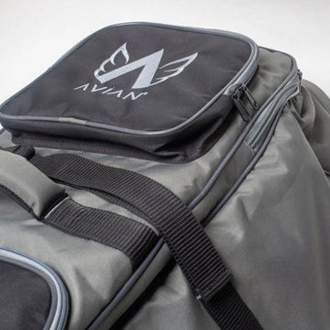 The Avian Gilmore V1 Flight bag in gray features black straps, a zippered pocket, the Avian logo, and a stylized wing design on top—ideal for bike travel or flights.