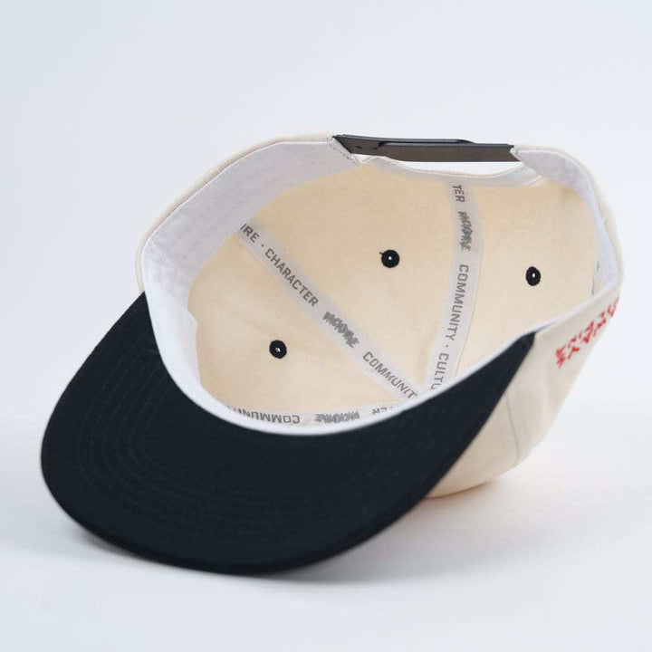 A beige and black Backbone Always Building Hat, photographed from below, shows the Backbone BMX embroidered logo along its inner band.