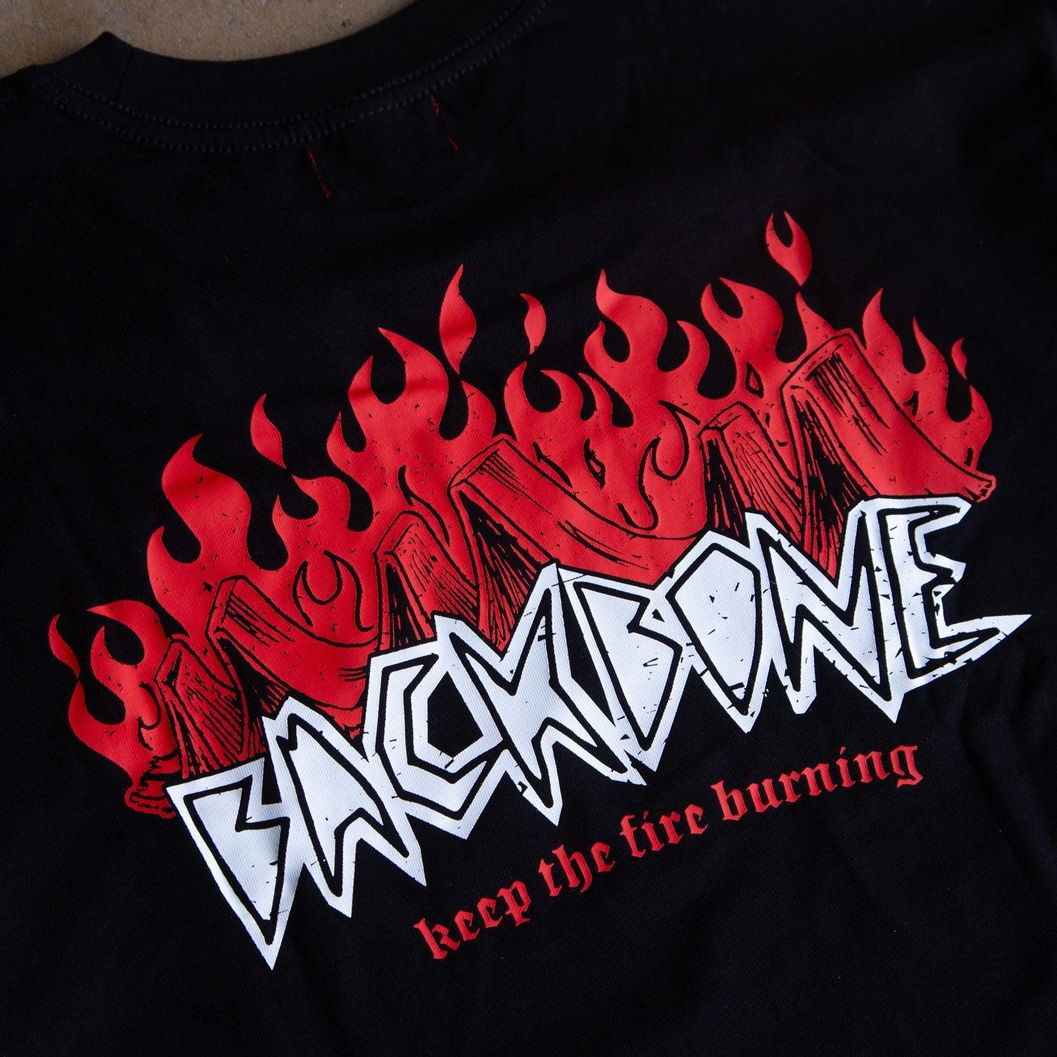 The Backbone Fire Burning T-Shirt is a black heavyweight tee with "BACKBONE" in bold white graffiti over red flames and "keep the fire burning" below. Inspired by Aussie BMX culture, it's made from premium cotton for comfort.