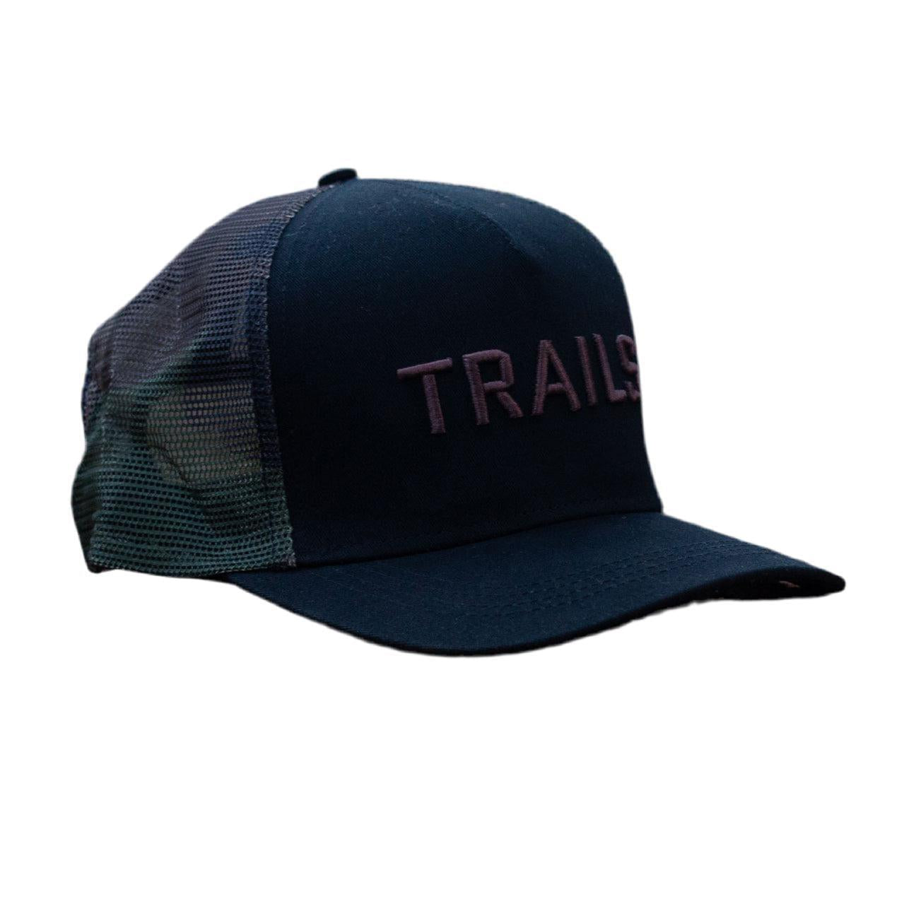 The Backbone Trails Trucker Hat showcases a dark purple "TRAILS" logo on the front and offers breathable style with a camo mesh back.