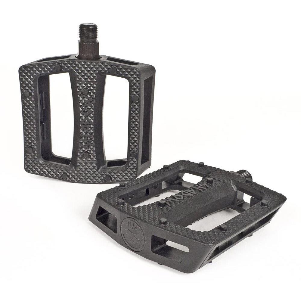 The Shadow Ravager Plastic Pedals are durable black pedals with textured, grippy surfaces and wide openings, shown on a white background.