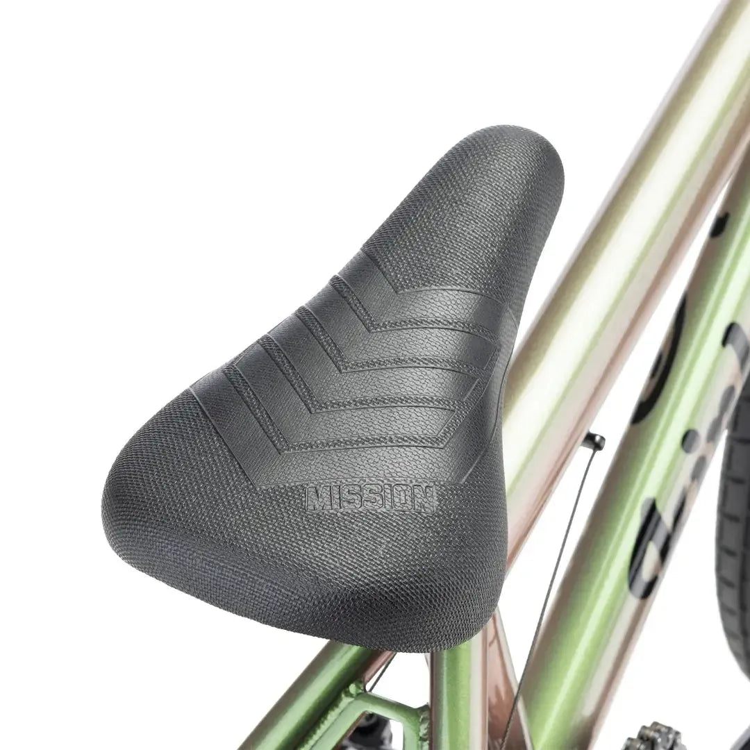 Close-up of a black textured seat on the metallic green frame of the Kink Carve 16 Inch Bike (2026), ideal for kids and beginners interested in BMX riding.