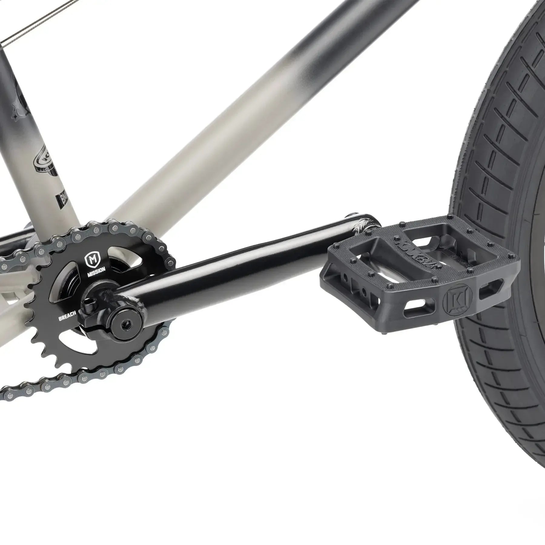 Close-up of the Kink Curb 20 Inch Bike (2026) drivetrain, highlighting its pedal, crank arm, chainring, and rear wheel tire—an ideal setup for entry-level BMX riders and beginners.