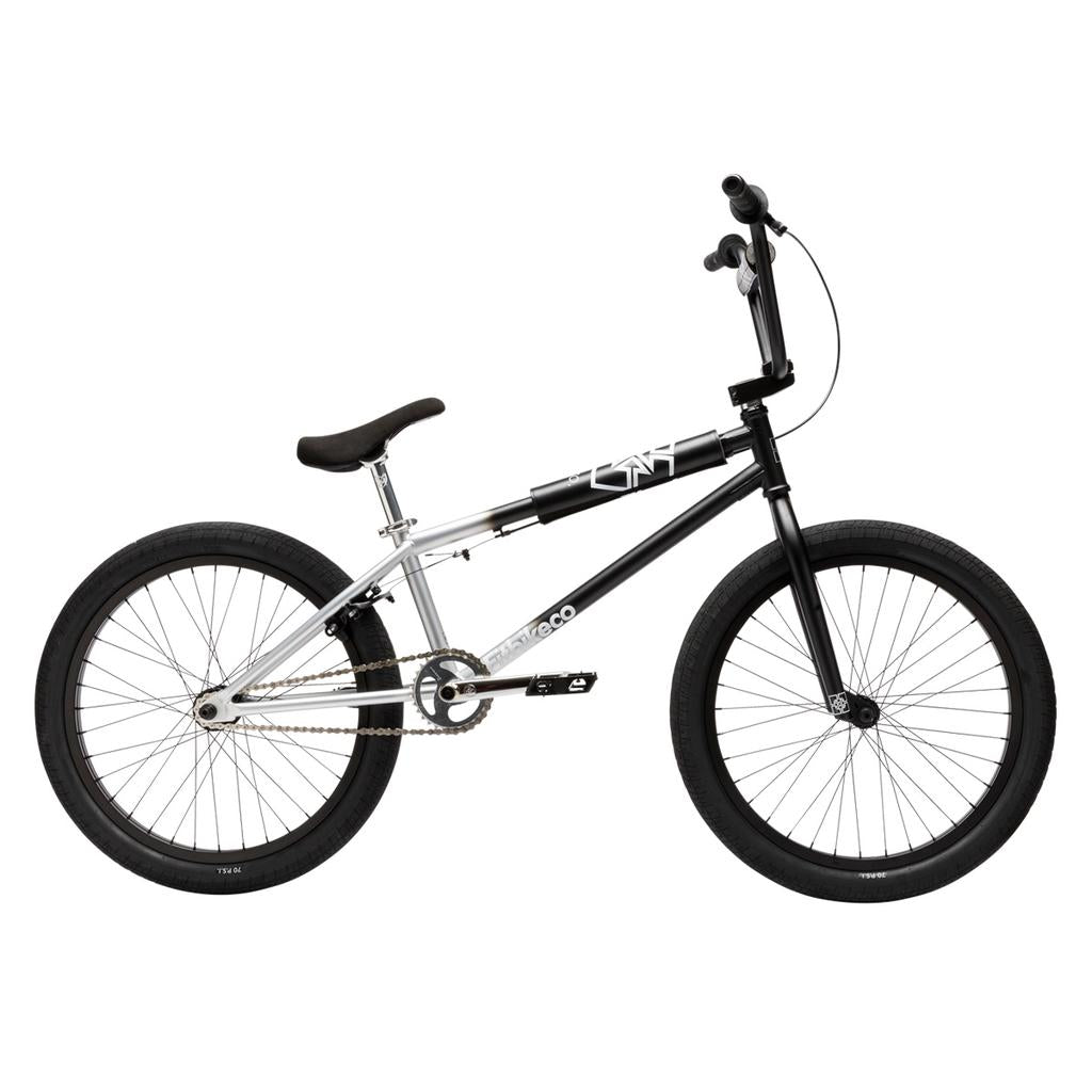 A side view of the Fit Bike Co Series 22 Inch Bike, featuring a black and silver frame, thick tires, padded seat, and straight handlebars. This BMX bike is designed for style and performance against a white background.