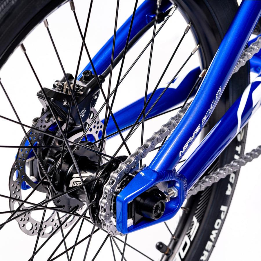 A close up of a blue Inspyre Evo Disc Junior Bike with a chain.