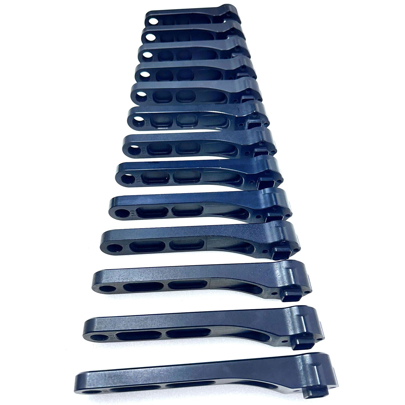 Fourteen Calculated VSR M4 Mini Cranks, resembling precision-crafted black metal parts from a Santa Cruz factory, are arranged diagonally on a white background.