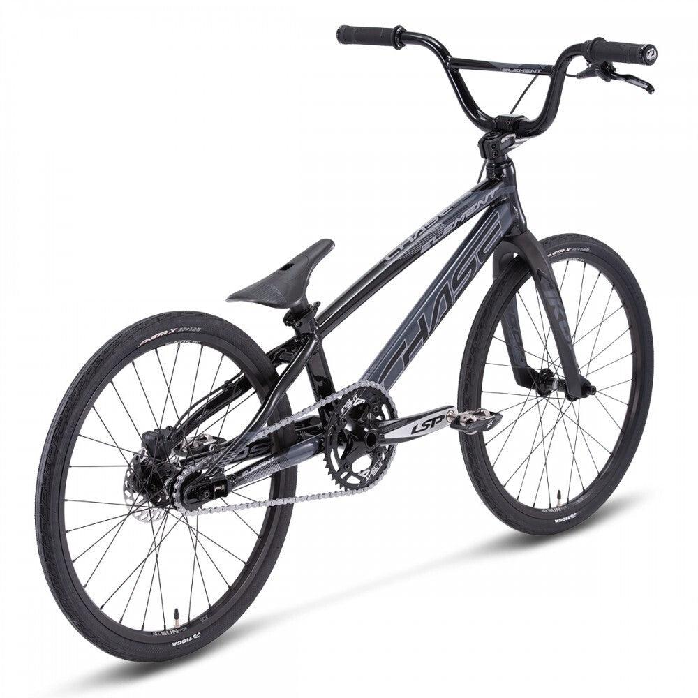 The Chase Element Expert Bike is a black BMX bike featuring a streamlined Expert XL frame, 20-inch wheels with knobby tires, and a single-speed drivetrain. It comes equipped with an angular handlebar, Ikon carbon forks, and a padded seat.