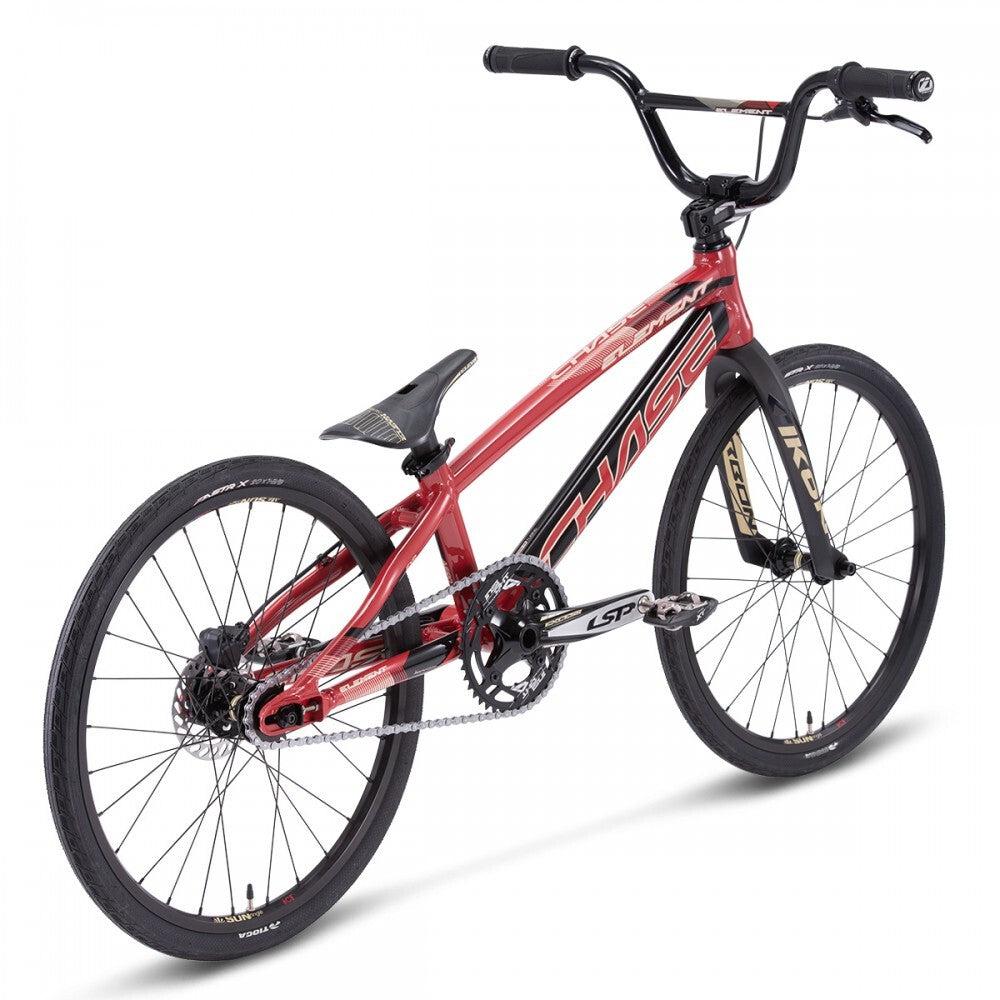 A sleek red and black Chase Element Expert Bike with “Chase Element” emblazoned on the frame. It boasts a single gear, hand brakes, Ikon carbon forks, and a padded saddle. Designed for racing, this bike features 20-inch wheels.