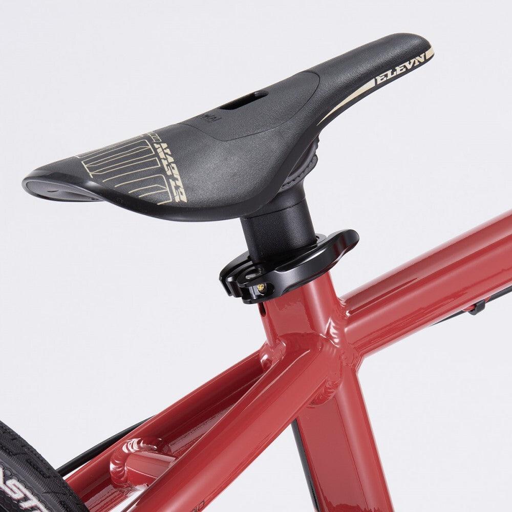 Close-up of a black bicycle saddle labeled "ELEVN," mounted on the red frame of a Chase Element Pro+ Cruiser Bike.