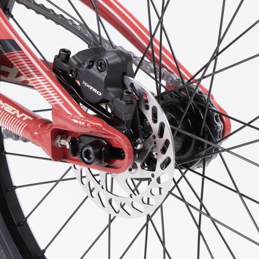 Close-up of a Chase Element Pro XXXL Bike *scratch and dent* rear wheel, showing a disc brake system with a black caliper, silver rotor on a red frame, and Ikon carbon forks.