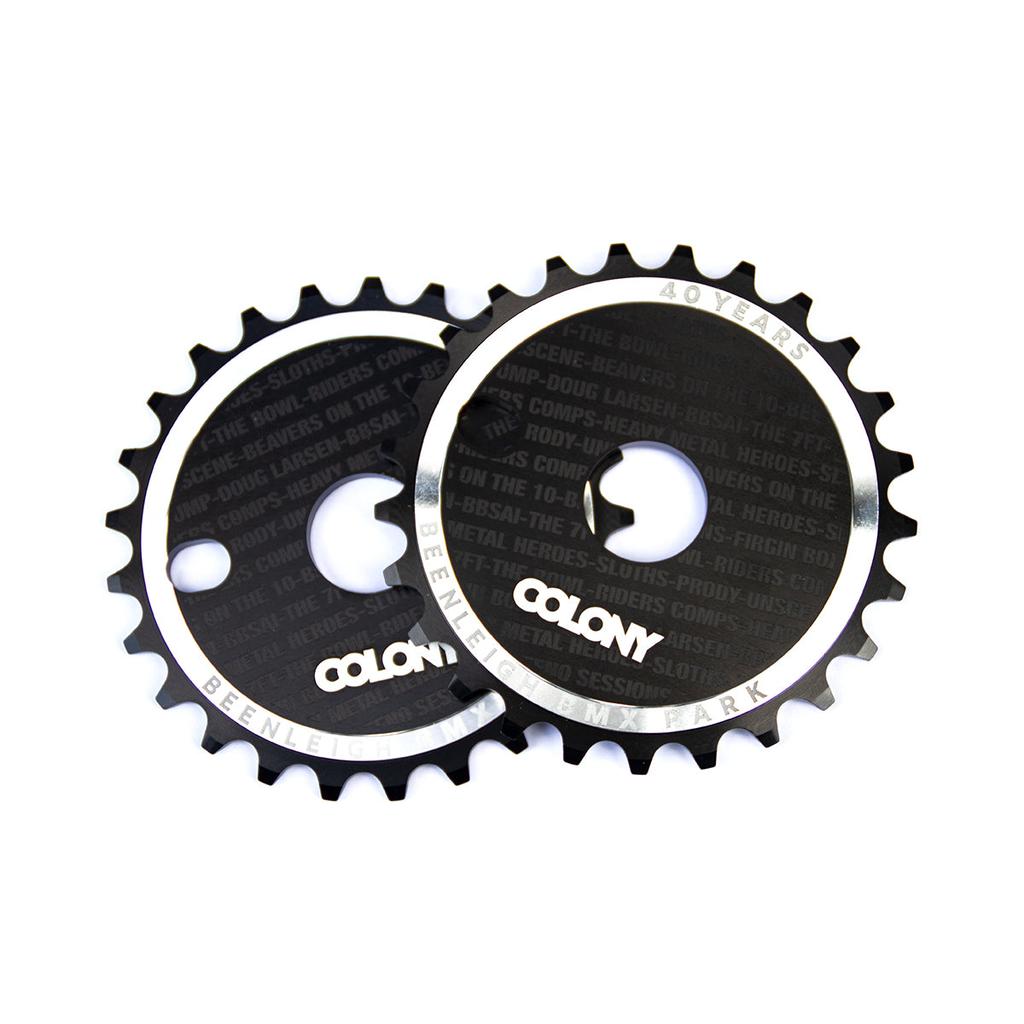The Colony Beenleigh 40 Years CD Sprockets, in striking black with glossy finish and circular center hole, celebrate Beenleigh BMX Park's 40-year legacy. Limited editions come with special inscriptions capturing the spirit of the iconic skatepark.