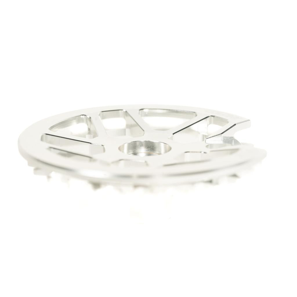 Close-up of a Colony Bish Guard Sprocket made from durable 7075-T6 aluminum, featuring a metallic, circular design with multiple slots and a central hole, viewed from a low angle.