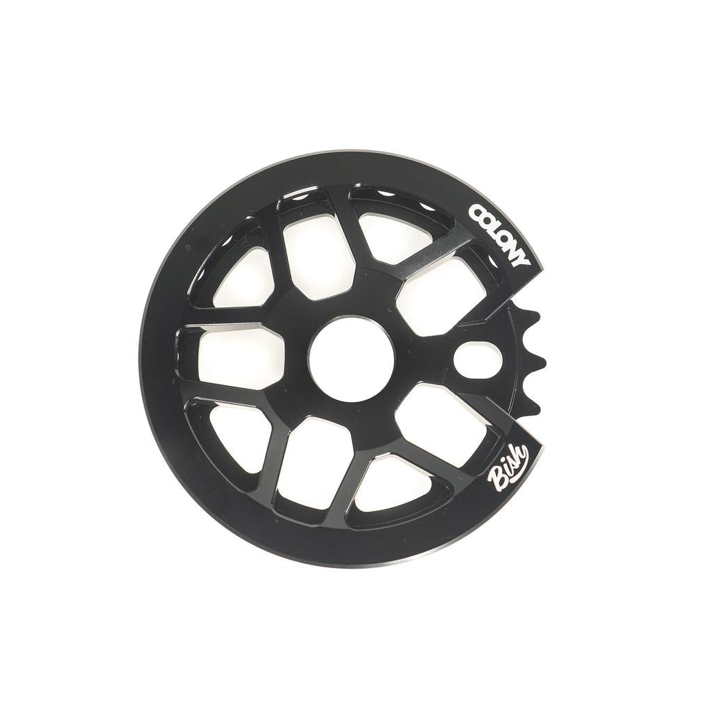 The Colony Bish Guard Sprocket is a black BMX sprocket with an integrated guard, made from durable 7075-T6 aluminum, featuring "COLONY" and "Bish" logos.