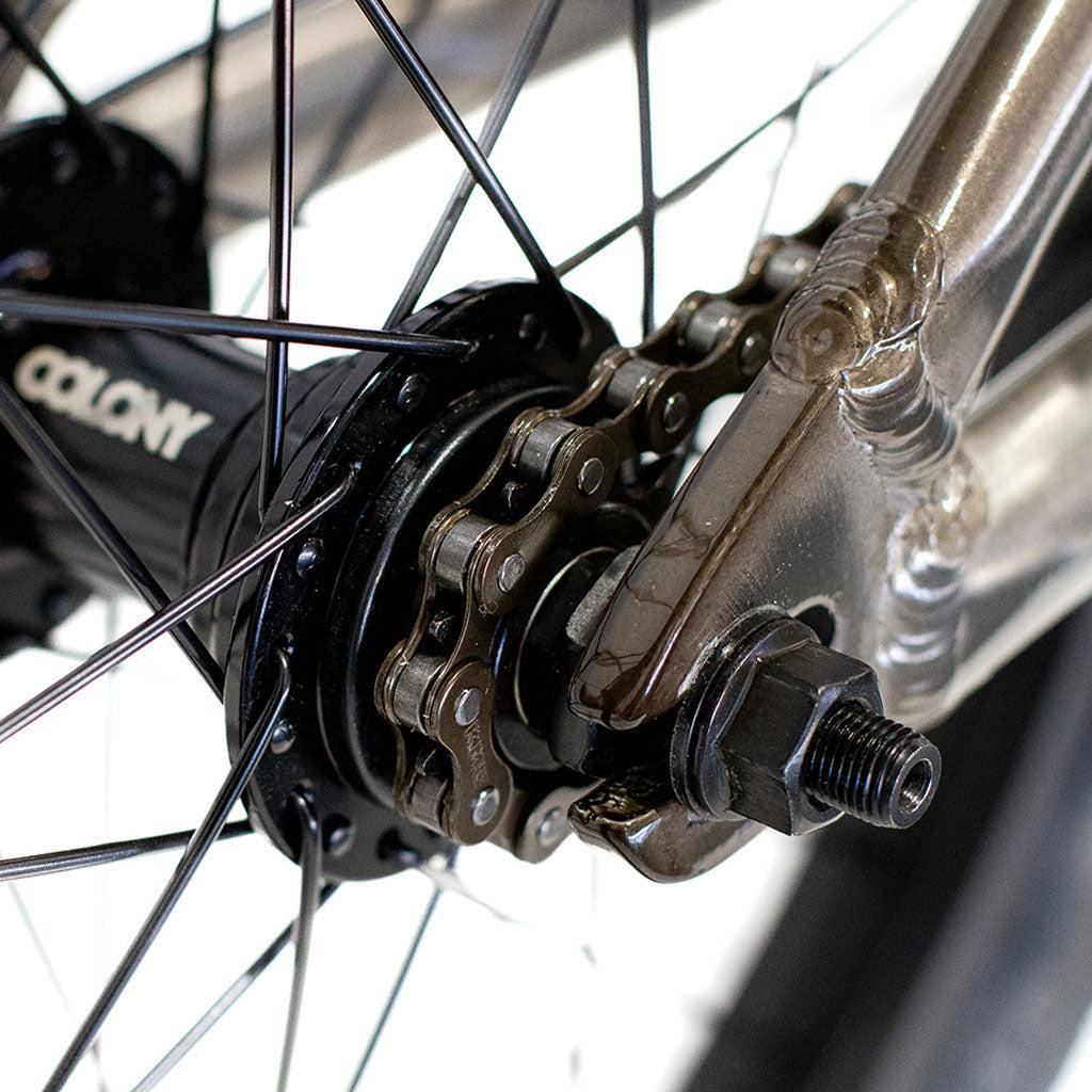 Close-up of the Colony Horizon 20 Inch Bike’s rear wheel hub, highlighting the chain, sprocket, axle, spokes, and lightweight alloy frame with visible welds.