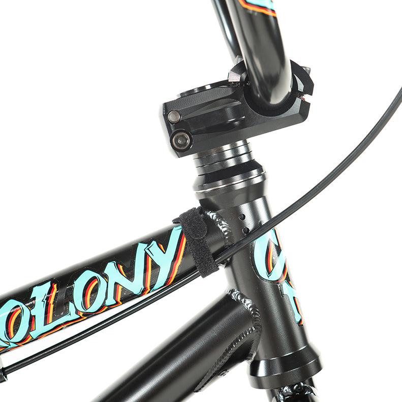 Close-up of a Colony BMX front frame branded in teal and orange. The image highlights the Sweet Tooth Pro Elite's handlebars and brake cable, capturing the essence of this 16 Inch BMX bike.
