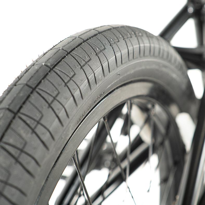 Close-up of a black tire from the Colony Sweet Tooth Pro Elite 16 Inch Bike, highlighting its detailed tread pattern and sleek spokes, reflecting the precision design of this BMX.