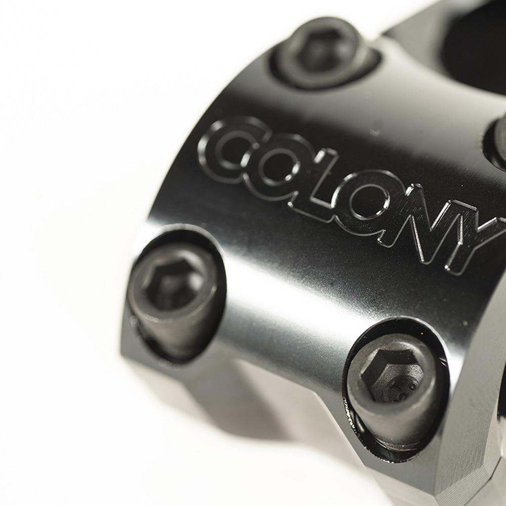 Close-up of the Colony Variant 35mm Stem, a black metal low-rise BMX stem with four hex bolts and "COLONY" engraving, designed to elevate your BMX riding experience.