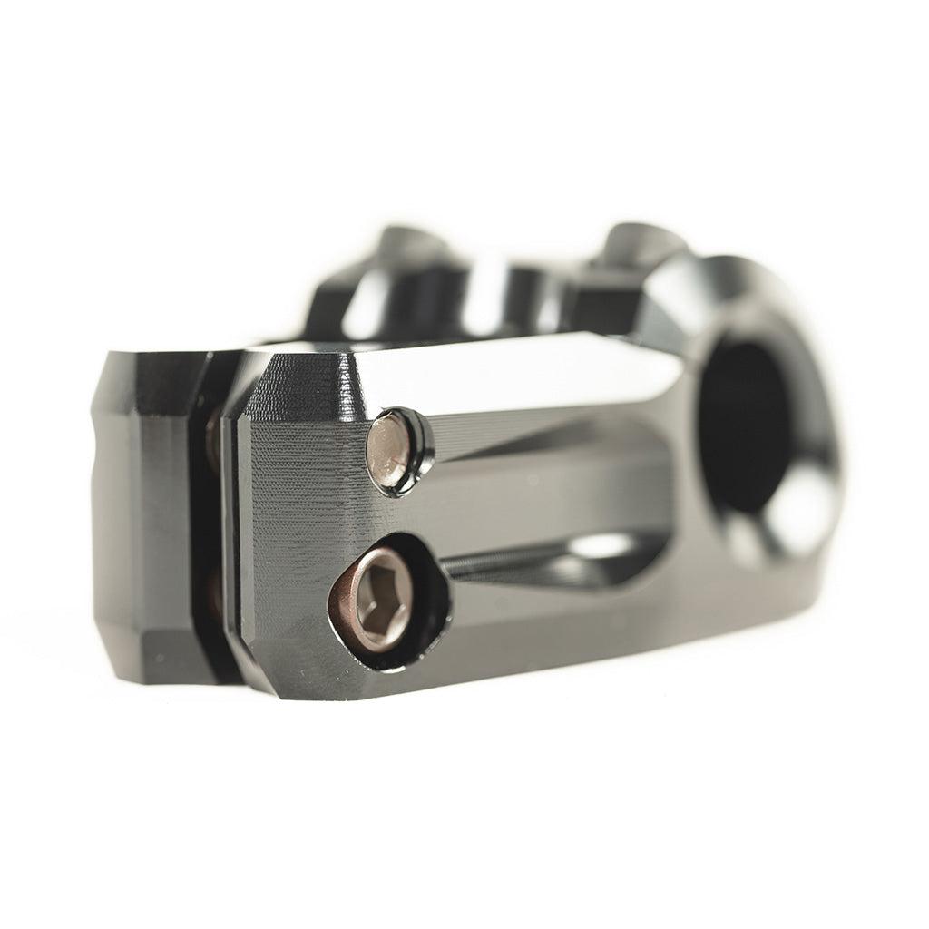 Close-up of the Colony Variant 35mm Stem in black, featuring bolts and a circular handlebar opening; this low-rise BMX stem is designed for an enhanced riding experience and is shown against a white background.