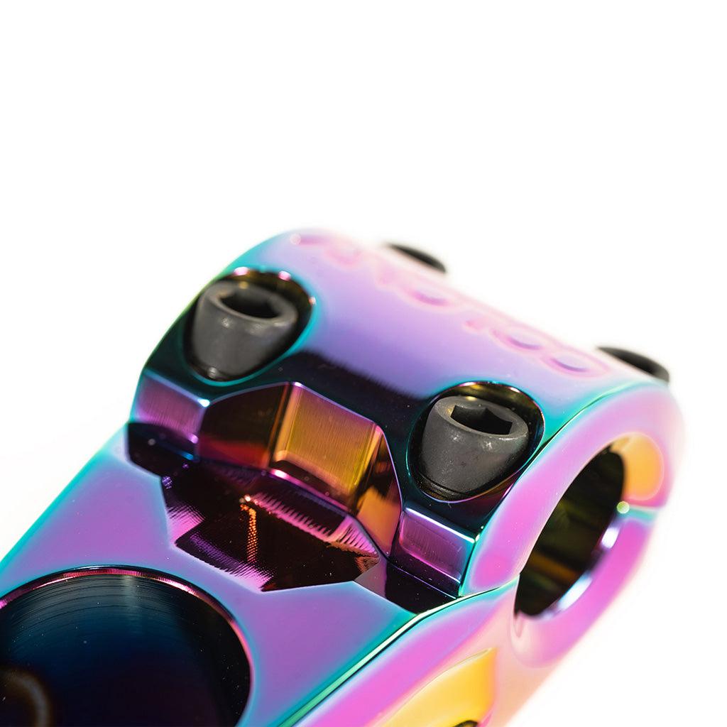 A close-up of a Colony Variant 52mm BMX Stem, a rainbow-colored, low-rise alternative to top load stems.