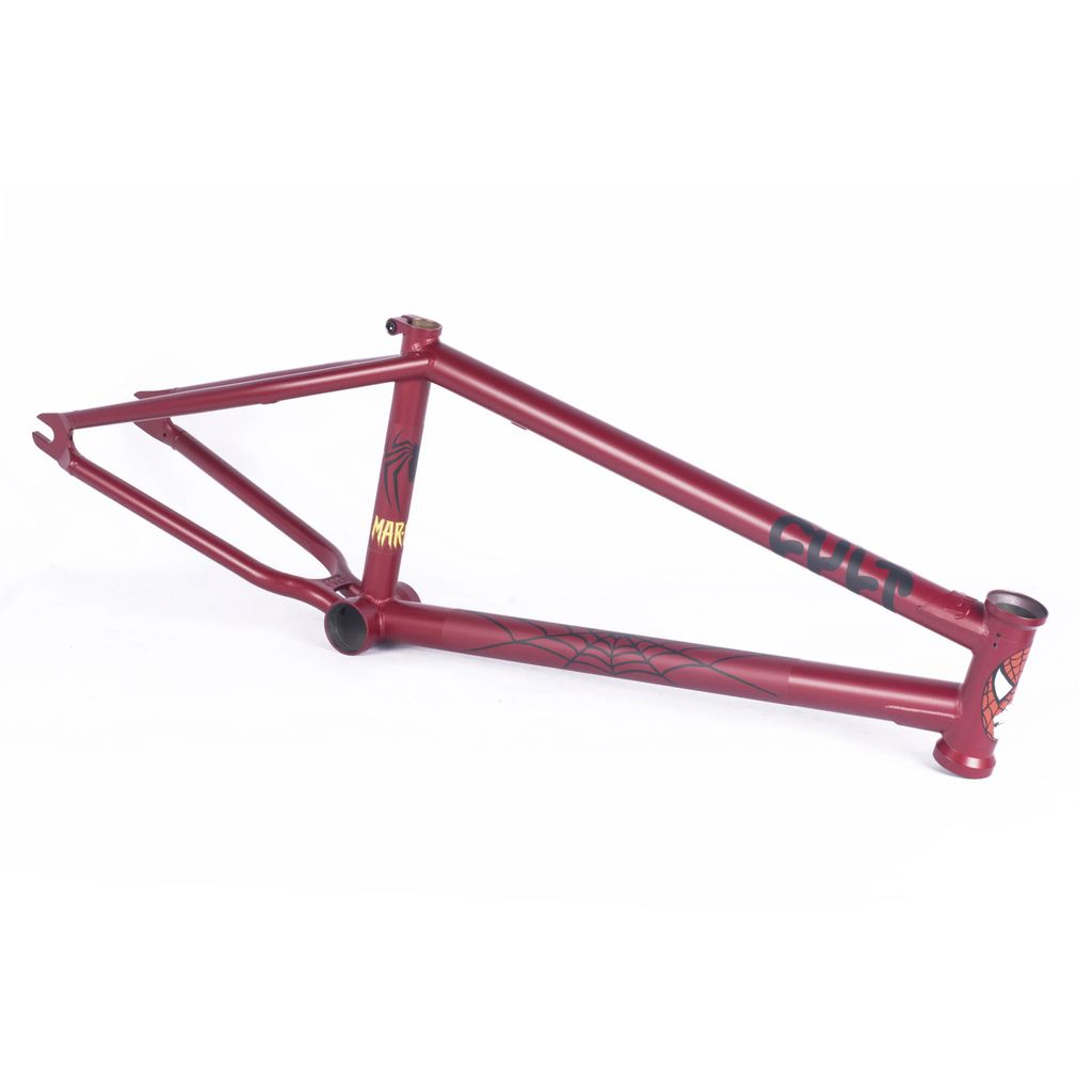 The Cult Heavens Gate Frame (Marcel Anderson Colourway) showcases a red BMX frame enhanced with a black spider web design and yellow text on the seat tube, complete with Spiderman graphics that add a superhero flair to its sleek structure.