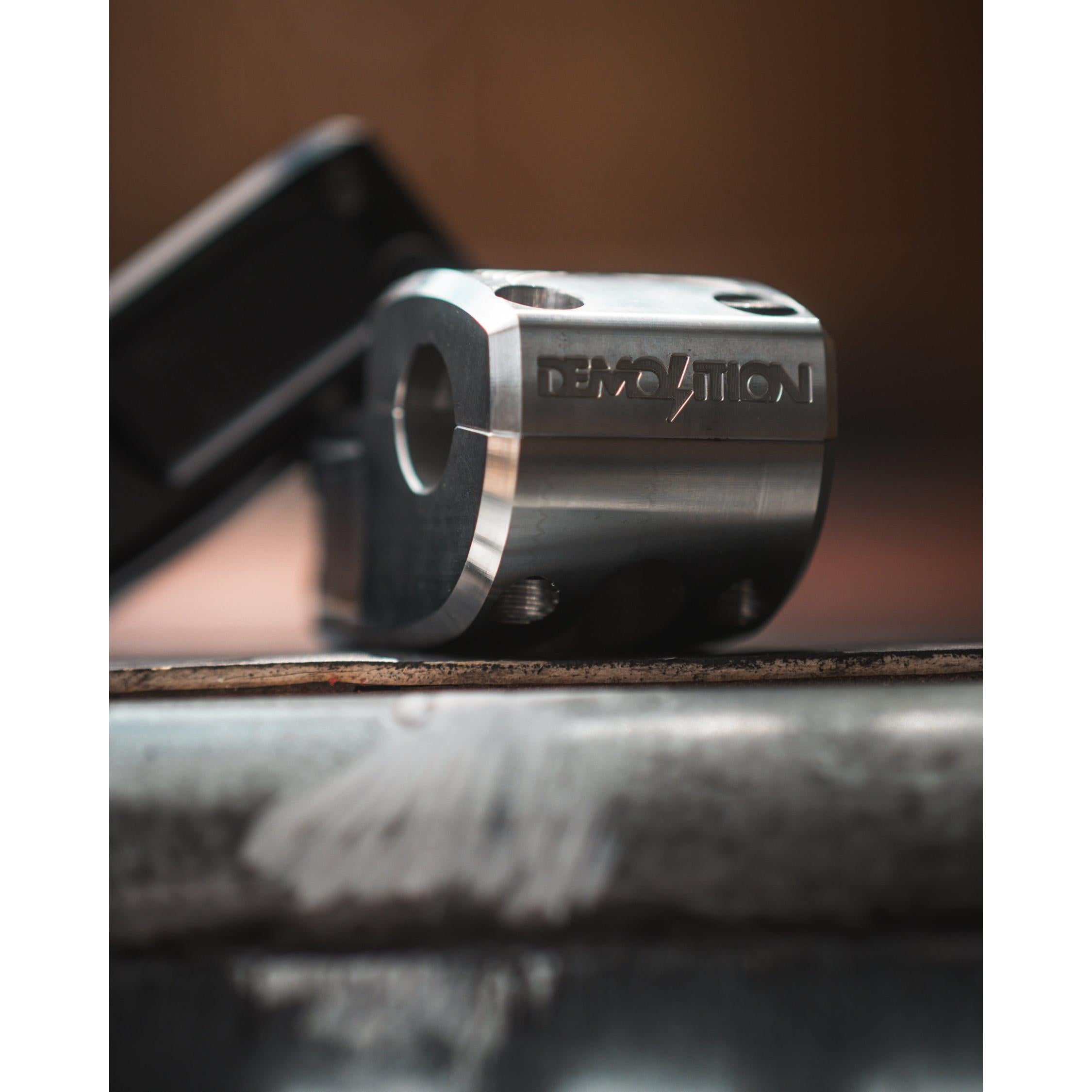 Close-up of a Demolition Josh Dove Stem featuring the iconic logo, resting on a textured surface.