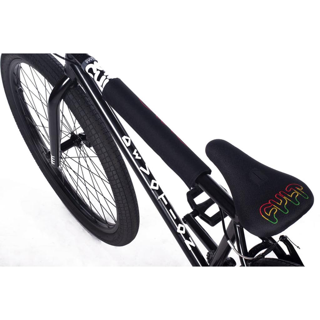 Close-up of the Cult Devotion 26 Inch Bike's rear wheel, seat, and top tube pad, showing its chromoly frame with white decals and a vibrant seat design.