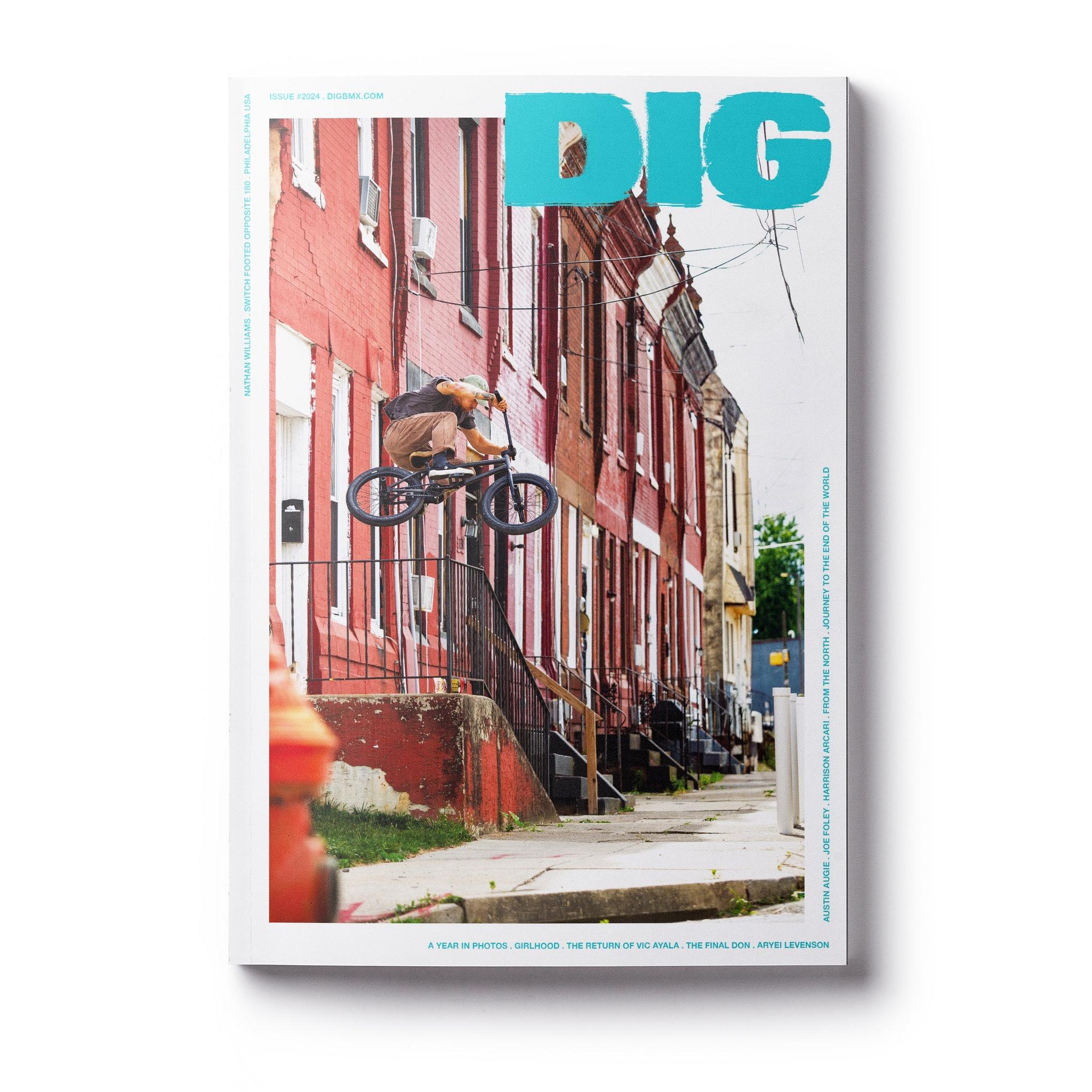 Magazine cover of DIG Book 2024 - Photo Annual showcases a cyclist jumping on a bicycle in front of red brick buildings.
