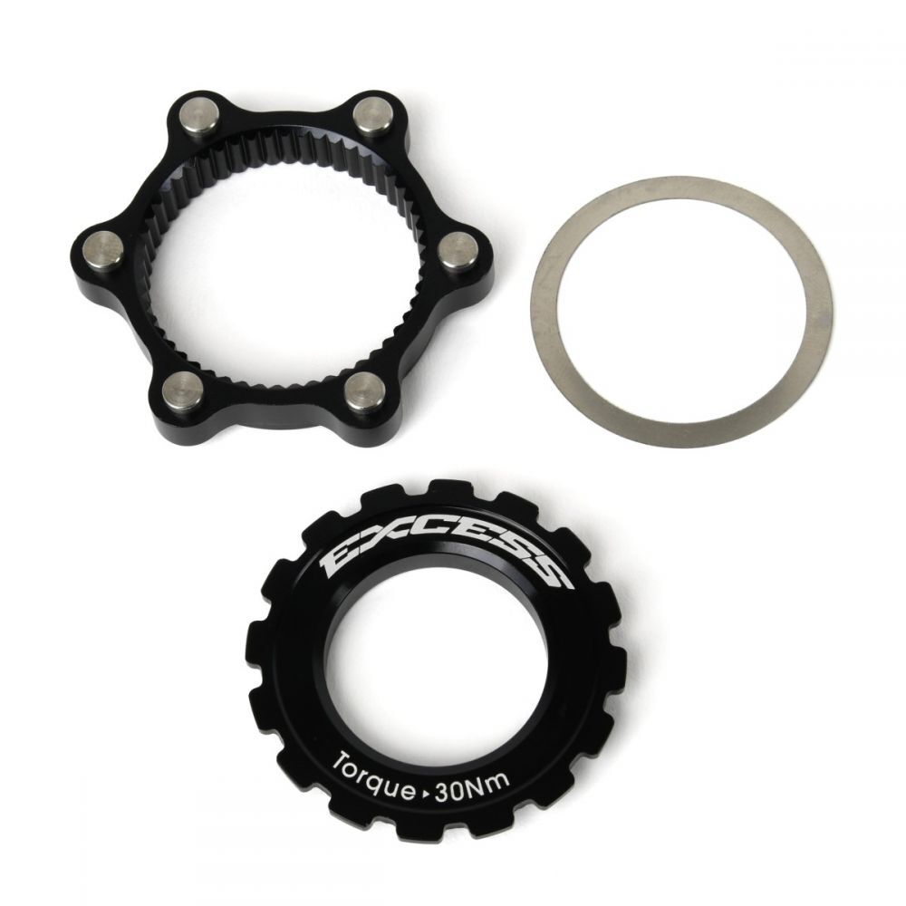 Three cyclocross bike components: a black sprocket marked “EXCESS” and “Torque 30Nm”, a toothed black ring, and a thin gray washer, arranged against a white background. Perfect for customizing your ride with the Excess Centerlock ISO Adapter Kit or upgrading to a 6-bolt disc brake rotor system.