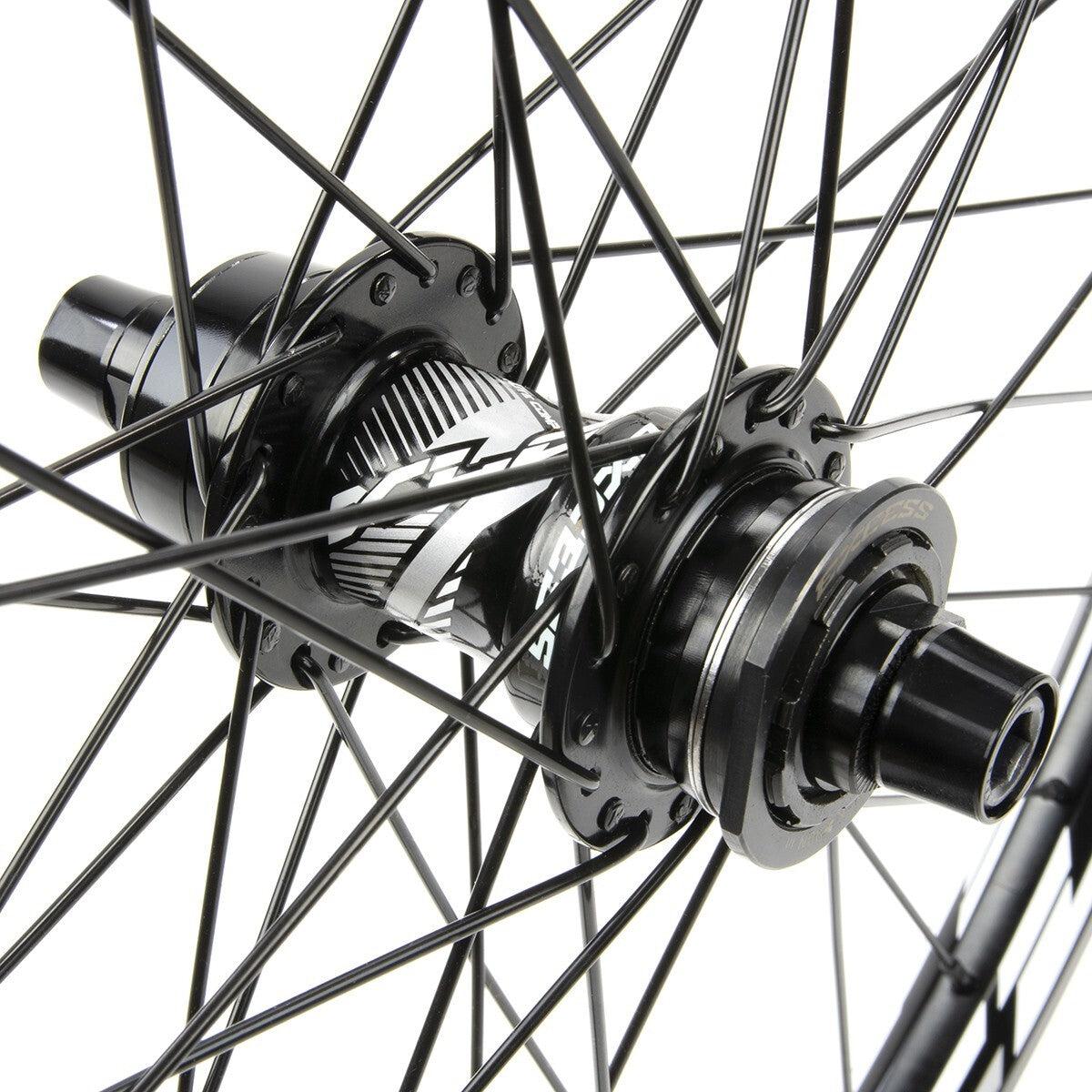 Close-up view of a BMX race wheelset’s cassette hub with black spokes and metallic parts, resembling the high-quality Excess XLC-1 Alloy Wheel Set 28H.