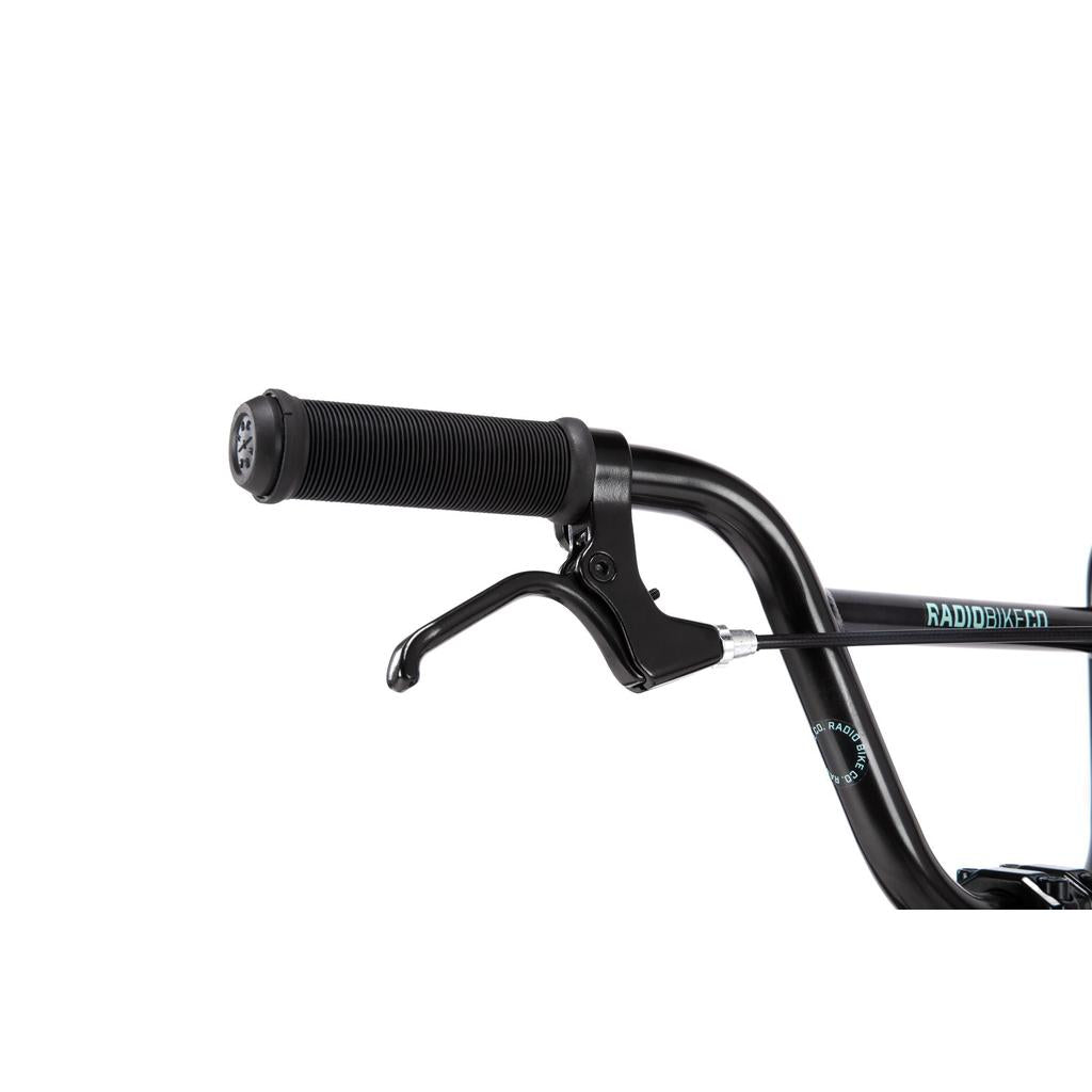 Close-up of a black BMX handlebar with textured rubber grip and brake lever, showing part of the "RADPOWER" name on the frame—just like the Radio Revo 14 Inch bike, ideal as your first ride.
