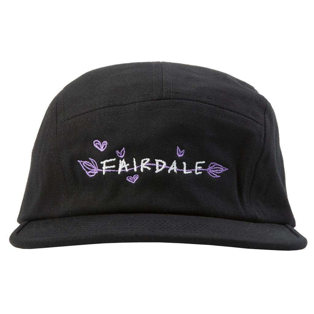 The Fairdale Nora V Camper Cap is a black five-panel hat featuring custom Nora bike-inspired artwork with "FAIRDALE" embroidered in white and purple, surrounded by small purple hearts and leaves.