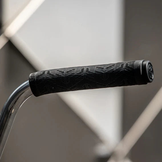 Close-up of a Federal Command Flangeless Grip in black, featuring a ribbed pattern on a metal handlebar, with a blurred background.