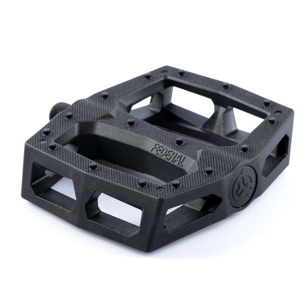 The Federal Command XL Plastic Pedals feature a textured black plastic body with multiple cutouts, ideal for BMX pedal tricks and crank arm grinds; shown here from an angled view.
