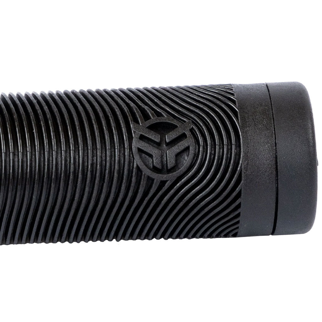 Close-up of the Federal Rewind Flangeless Grip, featuring a black cylindrical grip with a ribbed style design and a circular logo showcasing a stylized "Y" in the center, highlighting the super soft grip quality that Federal Rewind Grips is renowned for.