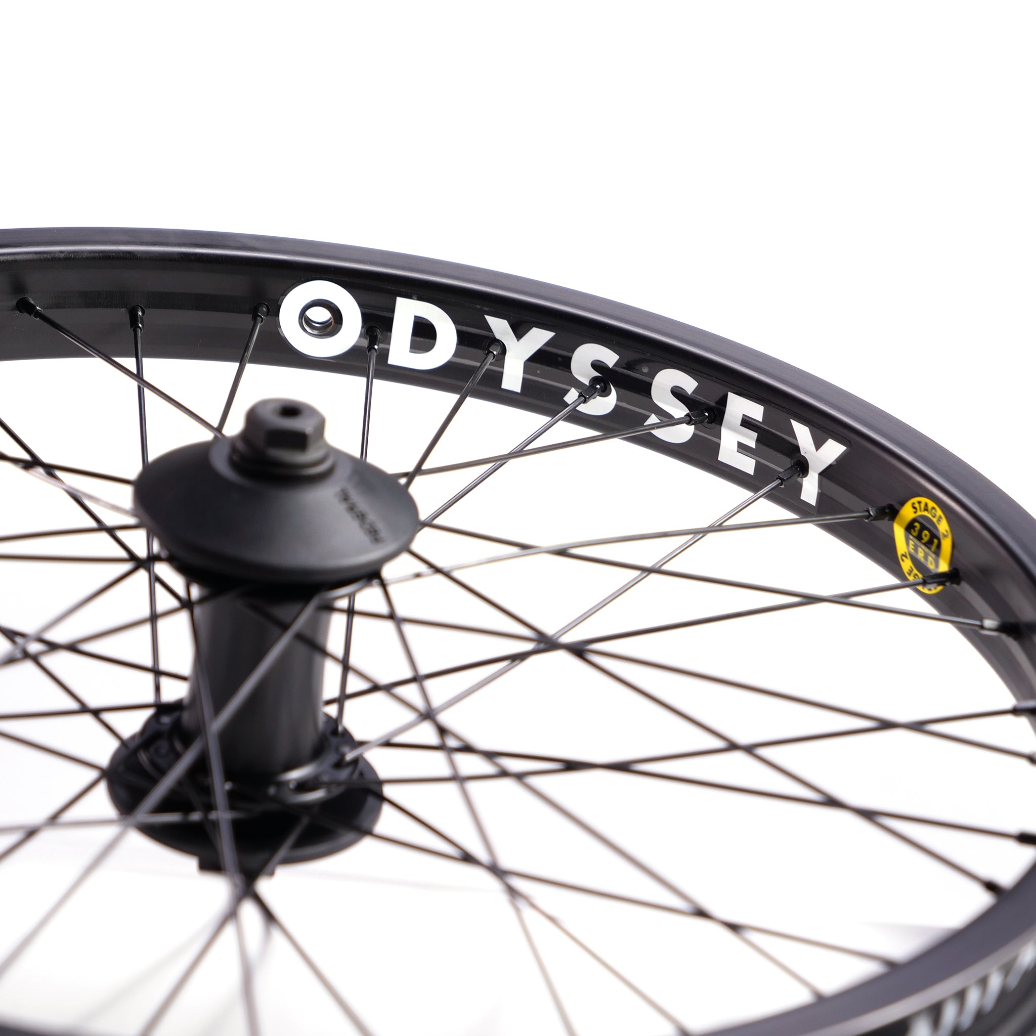Close-up of a black bicycle wheel with the brand name "Federal Stance Pro x Odyssey Stage 2 Custom Front Wheel" in white on the rim and multiple spokes radiating from the center hub.