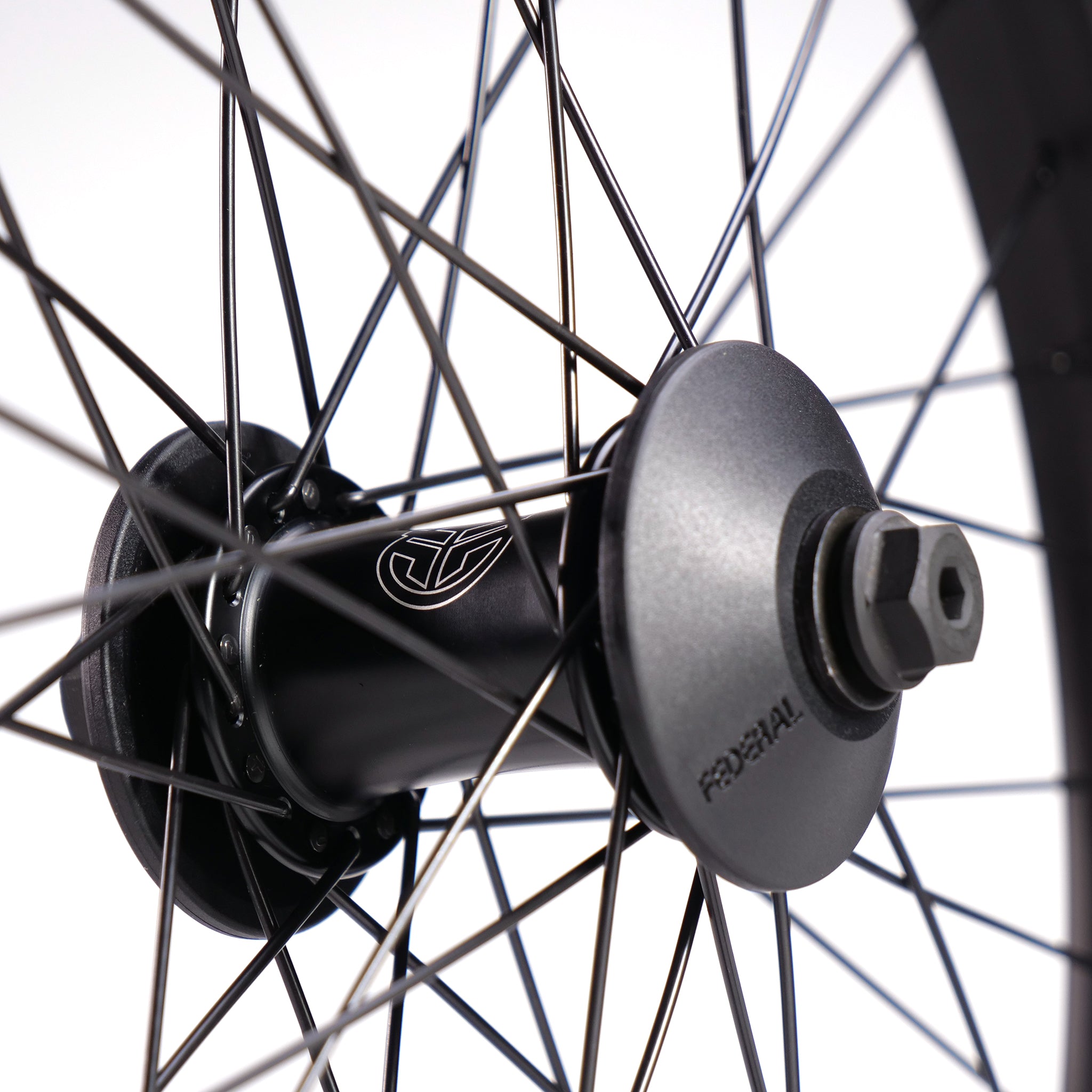Close-up of a bicycle wheel hub with multiple spokes radiating from it against a white background. The hub, emblazoned with the logo and the word "Federal," is part of the Federal Stance Pro x Odyssey Stage 2 Custom Front Wheel series.