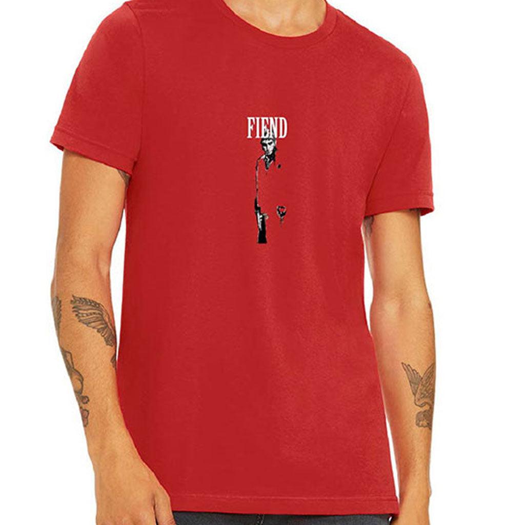 Man wearing a Fiend Tony Montana Shirt, featuring "FIEND" and minimalistic graphics printed on the chest. The T-shirt highlights tattooed forearms and uses discharge printing for a soft feel.