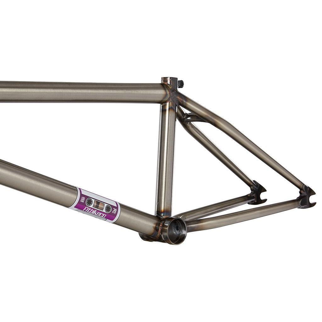 Close-up of the Fit Bike Co Mixtape Frame (Matt Nordstrom Signature) with a purple sticker. The minimalist titanium design showcases detailed welds, highlighting its responsive geometry.