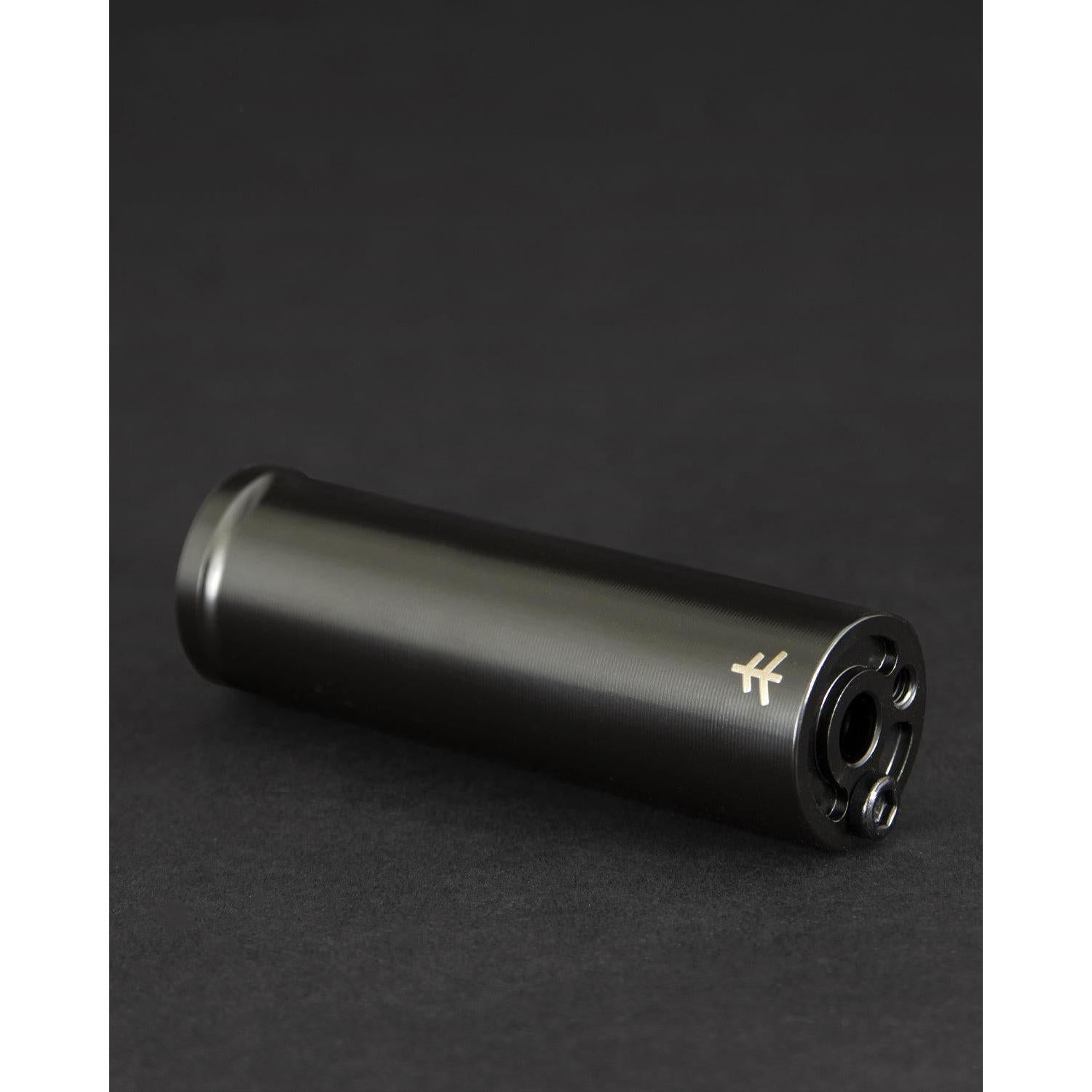 The Fly Bikes Acero TR Peg, a CNC machined 4140 Cr-Mo black cylinder with a logo, rests elegantly on a dark surface.