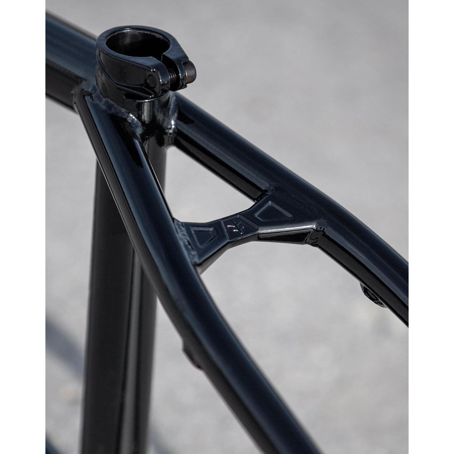 Close-up of a black Fly Bikes Dove 13.2 Frame (Josh Dove Signature), ideal for park riding, highlighting the seat clamp and rear triangle junction against a blurred gray background.