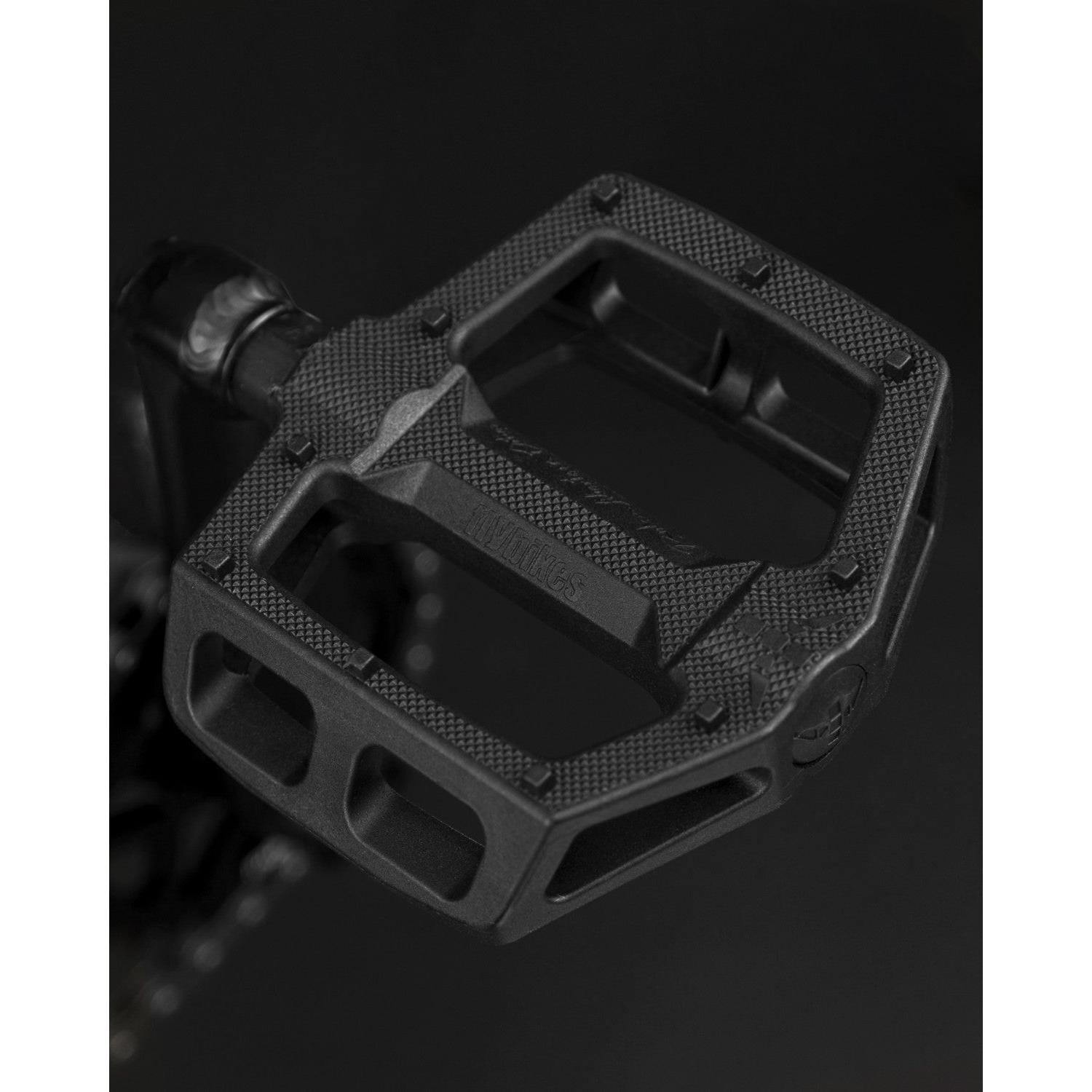 Close-up of a black bicycle pedal with a textured surface and sturdy, angular design, perfectly complementing the Fly Bikes Electron 20 Inch Bike equipped with a durable CrMo Crankset.