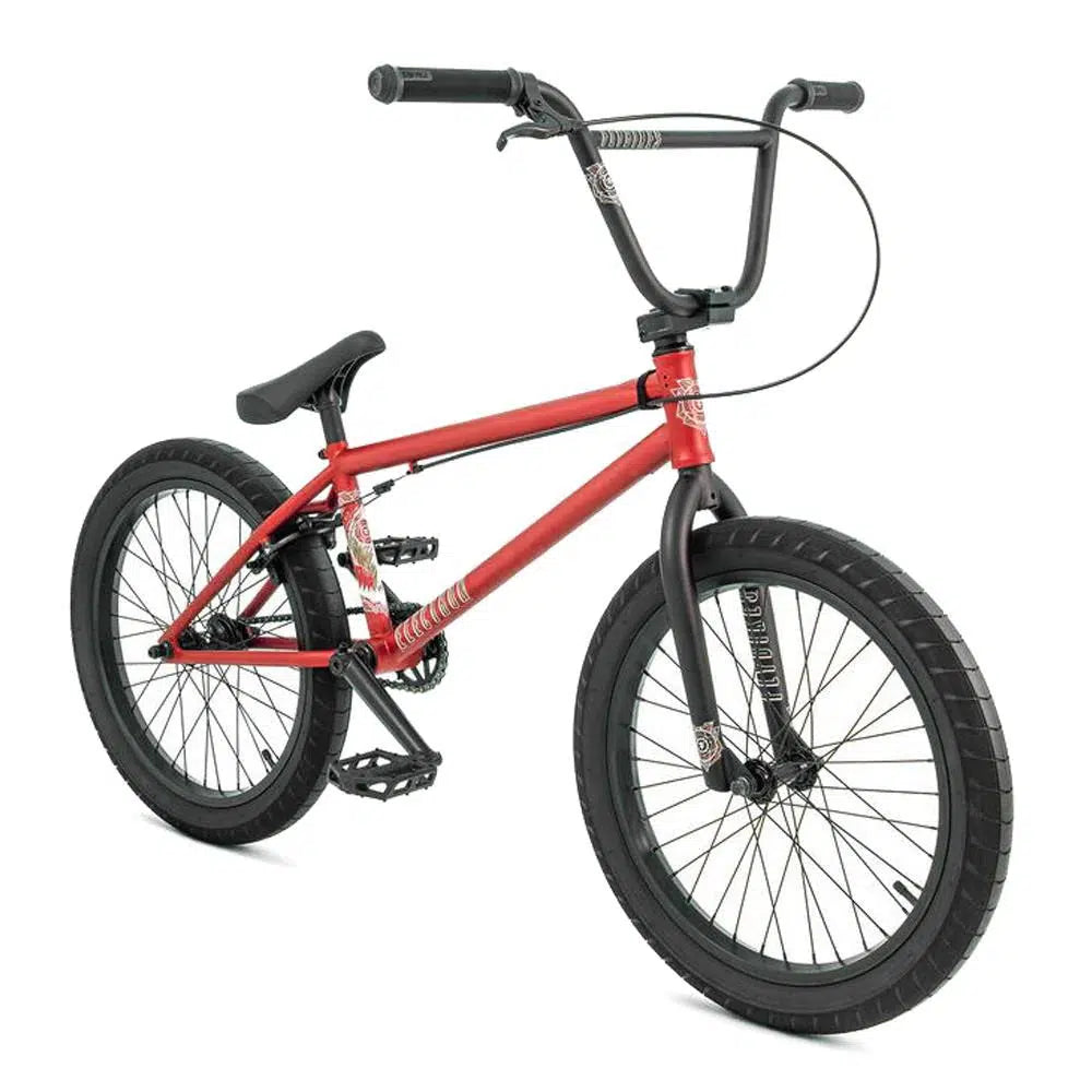 The Fly Bikes Electron 20 Inch Bike showcases a vibrant red frame constructed from CrMo material. It includes sleek black handlebars and robust Trebol Tires, beautifully displayed in a side profile against a clean white background.