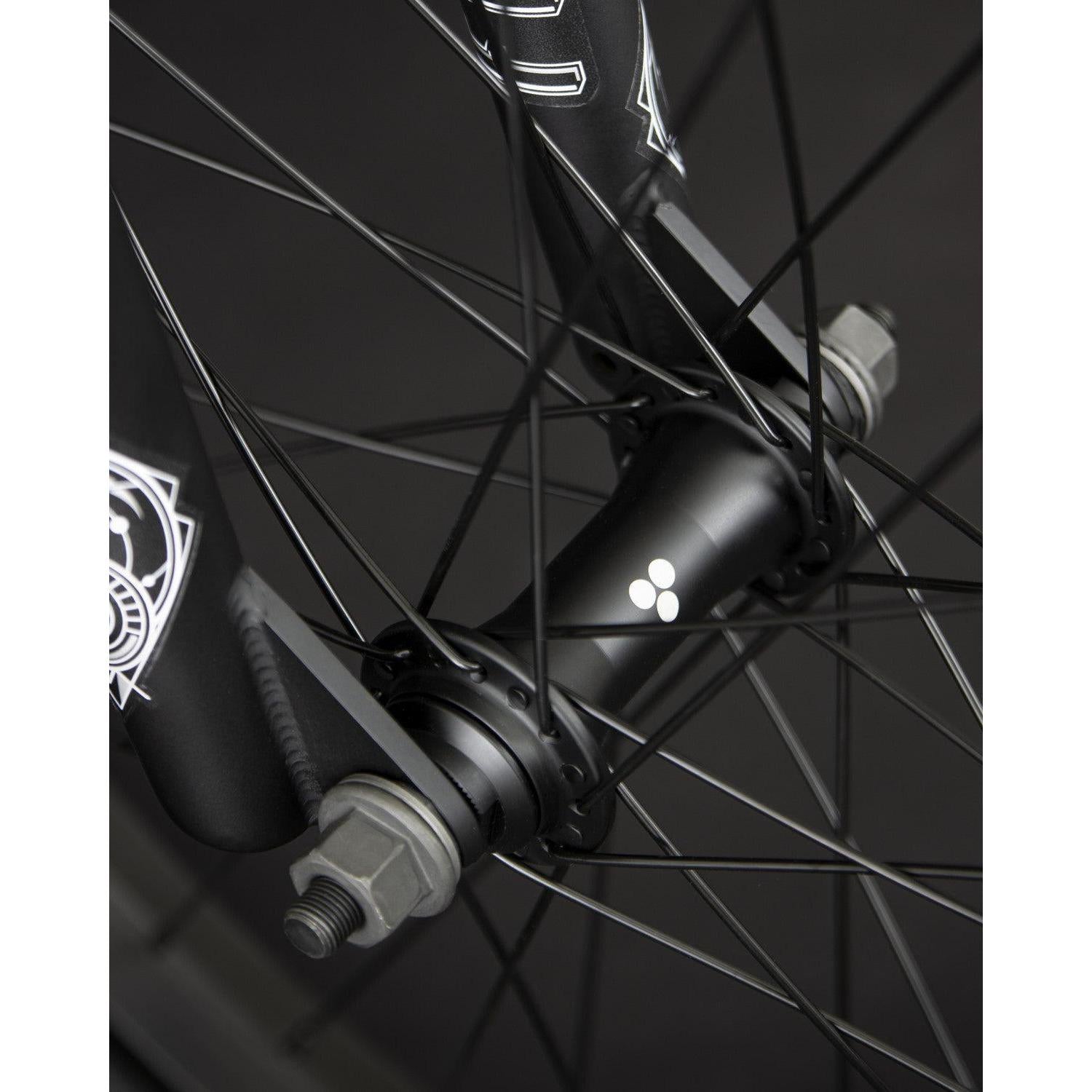 Close-up of the wheel hub with spokes and bolts on the Fly Bikes Neutron 20 Inch Bike, featuring a small white logo.