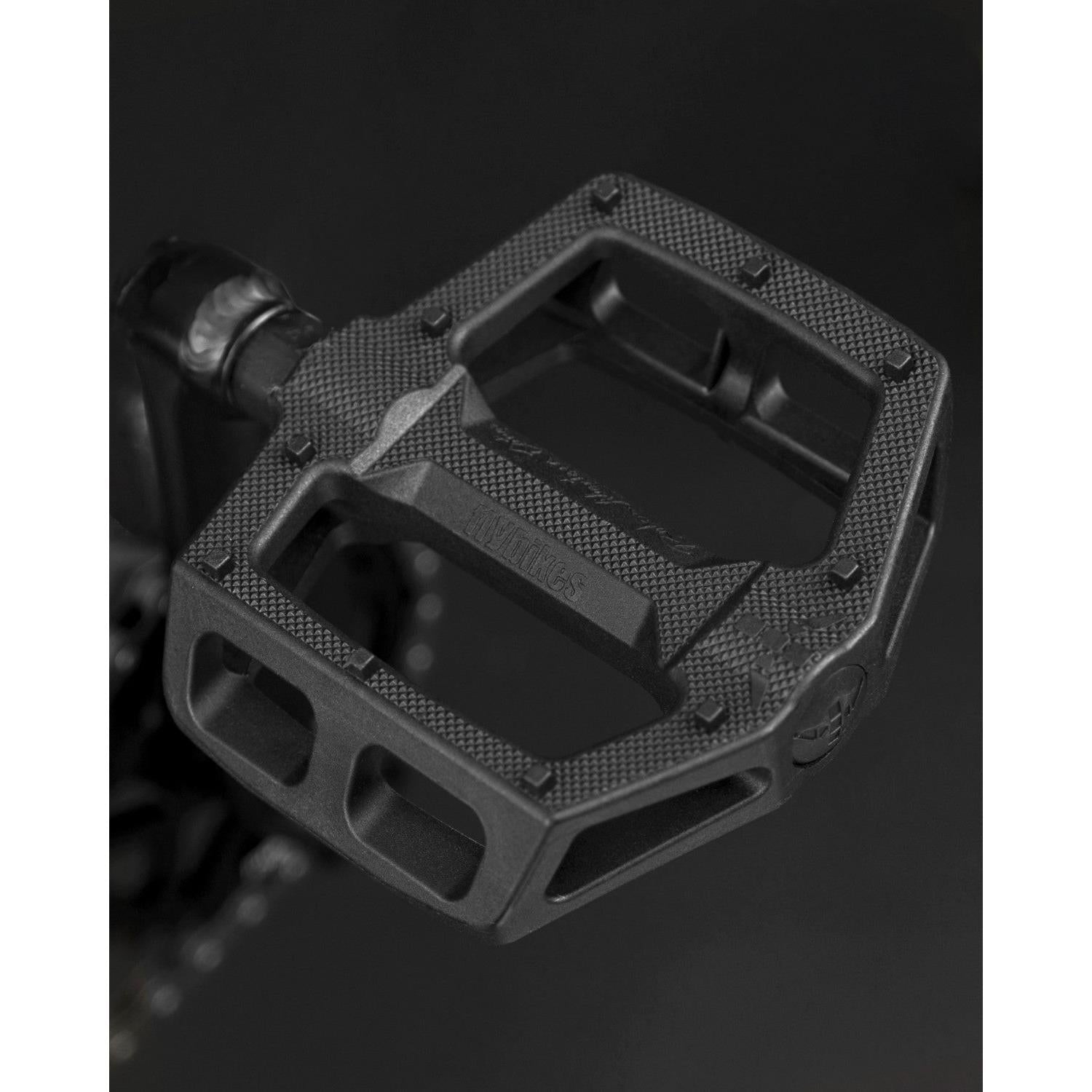 A close-up of a textured black bicycle pedal on a dark background, perfect for your next Fly Bikes Neutron 20 Inch Bike adventure.